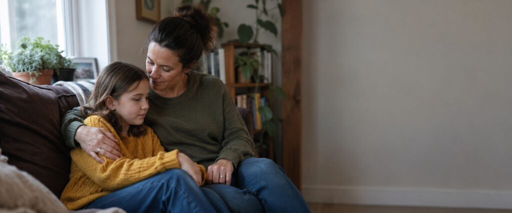 Parent gently reassuring their child at home, representing school refusal therapy in Pikesville, MD.